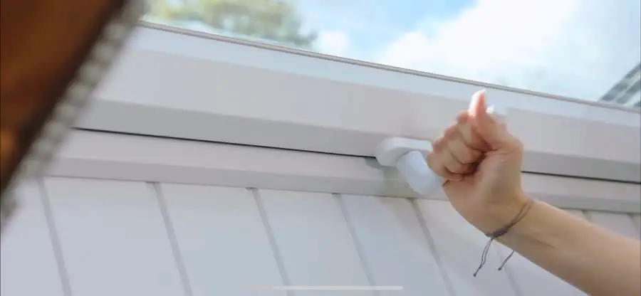 Hand bei der komfortablen Bedienung eines neuen Dachfensters